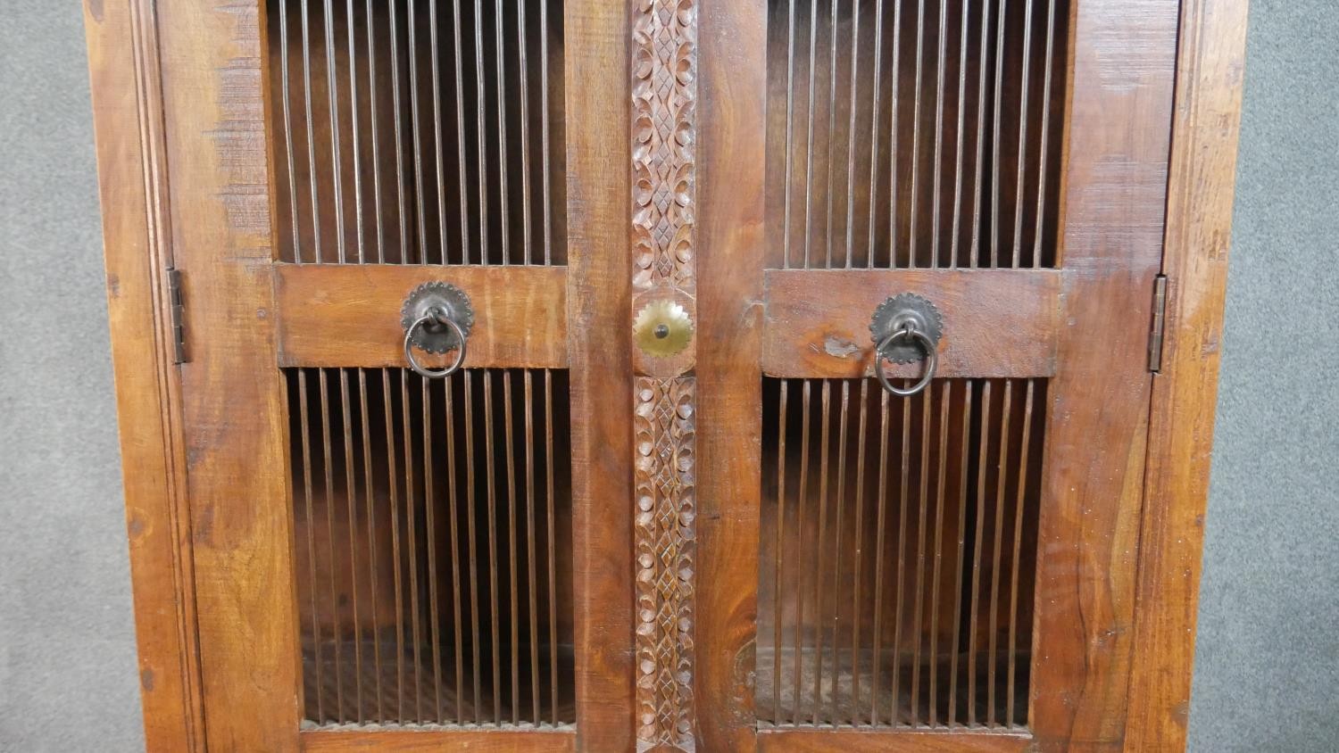 A 20th century Indian sheesham bookcase, the two doors with metal spindle panels, opening to - Image 3 of 8