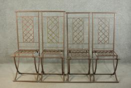 A set of four wrought iron folding garden dining chairs, with lattice back and seat.