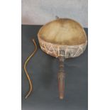 An African hide and gut drum with carved handle and beating stick. L.67 W.37cm