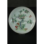 A Famille Rose Chinese porcelain nine peaches plate, decorated with lucky bats, grapes and a peach