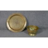 A large Indian engraved design brass tray along with a pedestal bowl filled with eight hand