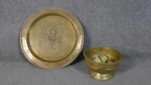 A large Indian engraved design brass tray along with a pedestal bowl filled with eight hand