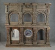 An Indian carved hardwood shrine, with two tiers of recesses, formerly containing mirror plates, two