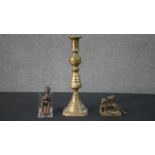 A 19th century brass candlestick along with an African bronze figure and a brass winged lion
