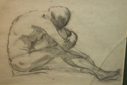 A framed and glazed charcoal drawing of a seated nude. Unsigned. (cracked glass) H.45 W.57cm.