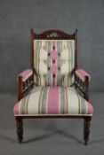 A late Victorian walnut armchair, upholstered in ivory, pink, blue and green striped fabric with a