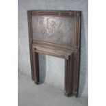 An Art Nouveau carved and repousse wooden fireplace surround, the wooden panel depicting various