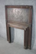 An Art Nouveau carved and repousse wooden fireplace surround, the wooden panel depicting various