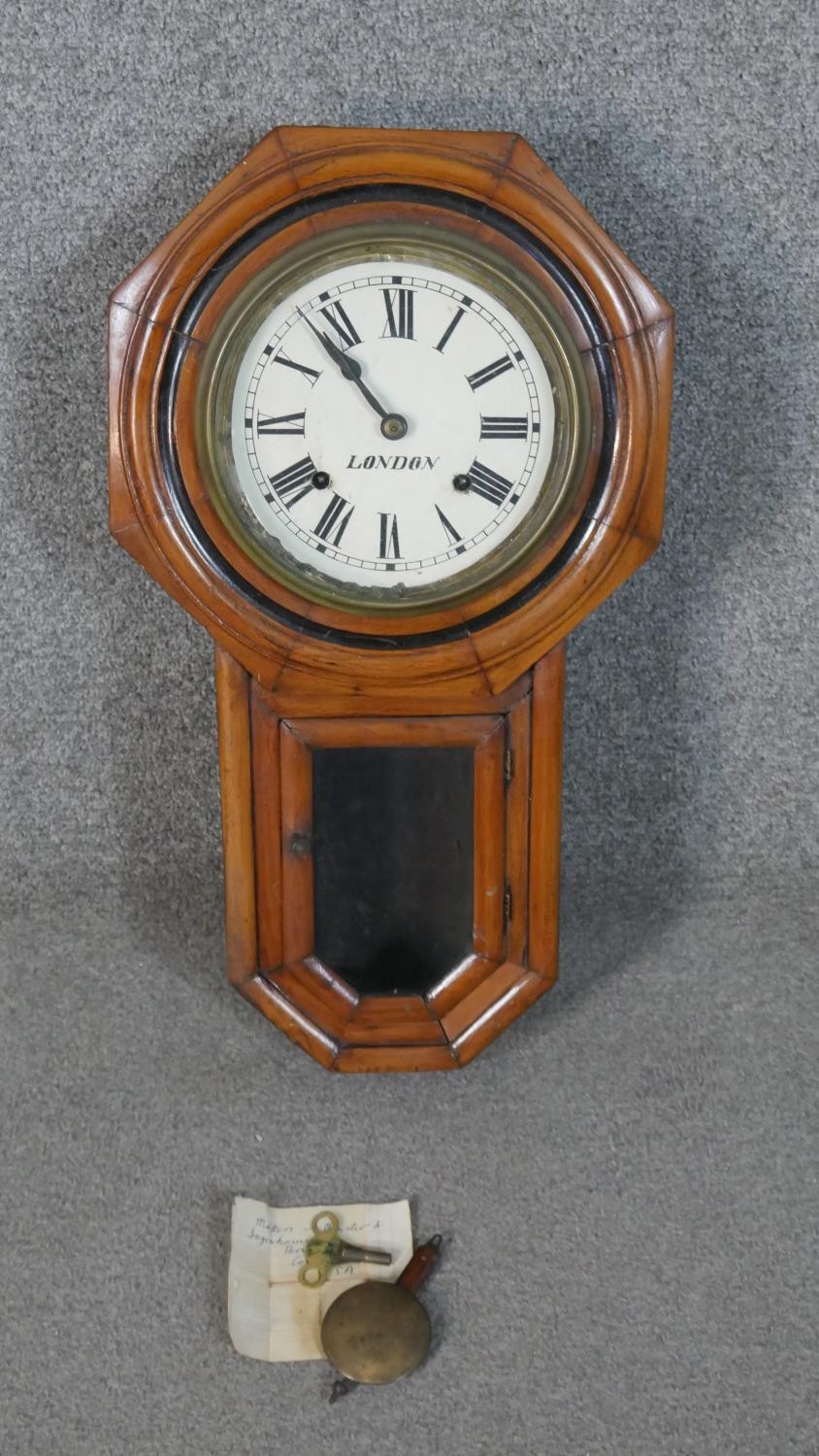 A late 19th century wall clock, the circular painted dial in an octagonal frame, with Roman