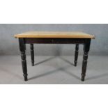 A Victorian pine kitchen table, with a rectangular top over an end drawer, on a black painted base