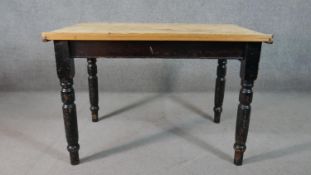 A Victorian pine kitchen table, with a rectangular top over an end drawer, on a black painted base