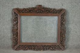 An early 20th century Chinese carved and pierced hardwood frame, ornately decorated with various