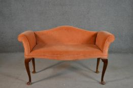 A George III style mahogany hump back window seat, upholstered in salmon coloured velour, on