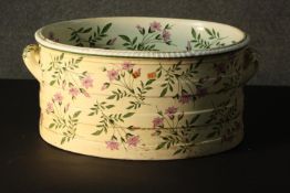 A 19th century porcelain foot bath, with a gadrooned rim and twin handles, painted with flowers to