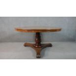 A Victorian circular mahogany tilt top breakfast table, with a turned stem, on a tri-form base