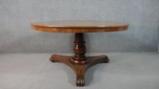 A Victorian circular mahogany tilt top breakfast table, with a turned stem, on a tri-form base