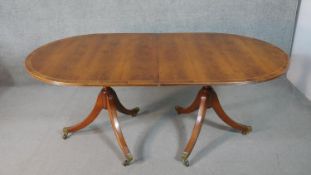 A George III style yew wood D-end dining table, with a cross banded top and additional leaf, on