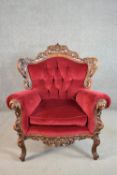 A 20th century continental walnut armchair, upholstered in red velour, with a button back, the frame
