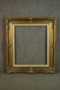 A large 20th century pine and resin gilded picture frame with moulded detailing. H.88 W.77cm.