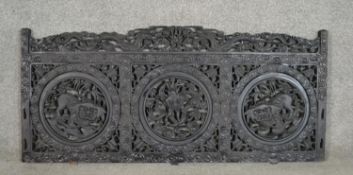 A Chinese carved hardwood panel, the top rail with two fragons flanking a flaming pearl, over