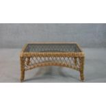 A late 20th century woven wicker coffee table, of rectangular form with a smoked plate glass top.