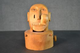 An early 20th century carved automaton in the form of a gentleman's head. The mouth, eyes and cheeks