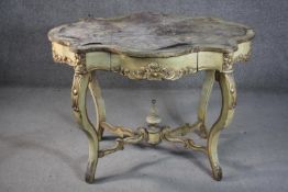 An Italian painted and parcel gilt centre table, of cartouche form, with a leather insert, above a