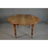 A Victorian figured walnut drop leaf dining table, the circular top with a moulded edge, on