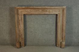 A limed oak fire surround, of moulded form with a bead and reel border. H.120 W.137cm.