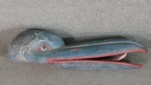 A carved and painted oriental birds head. H.18 W.78cm