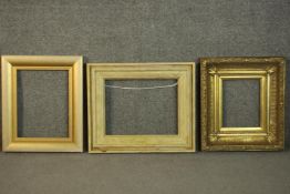 Two gilt picture frames and a similar stained pine frame. H.47 W.54cm. (largest)