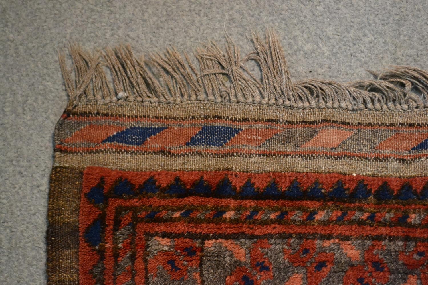 A handmade Afghan carpet with repeating gul motifs on a burgundy field within stylised borders. L. - Image 6 of 7