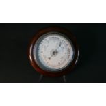 A circular mahogany aneroid barometer, the dial marked 'British Made'. Diam.25cm
