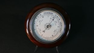 A circular mahogany aneroid barometer, the dial marked 'British Made'. Diam.25cm