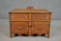 An early 20th century teak sideboard, with a gallery back over two short drawers and two cupboard