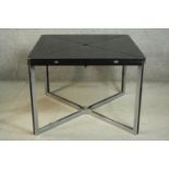 A modernist envelope extending dining table, with a black stained ash extending top, on chromed legs