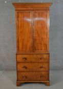 An early 19th century mahogany linen press, of narrow proportions, with two cupboard doors,