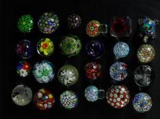 A collection of twenty four art glass paperweights, various designs and patterns, some with cane and