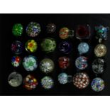 A collection of twenty four art glass paperweights, various designs and patterns, some with cane and