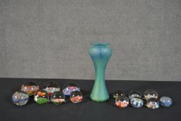 A collection of fourteen art glass paperweights and a signed art glass vase with feathering