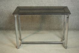 A modernist side table, with a rectangular smoked glass top on a chromed steel base. H.71 W.99 D.