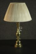 A brass candlestick, converted to a lamp, with a baluster and turned body, and a pleated shade. H.60