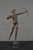 An Art Deco style spelter figure of a nude woman with bow, mounted on a black onyx base. H.62cm