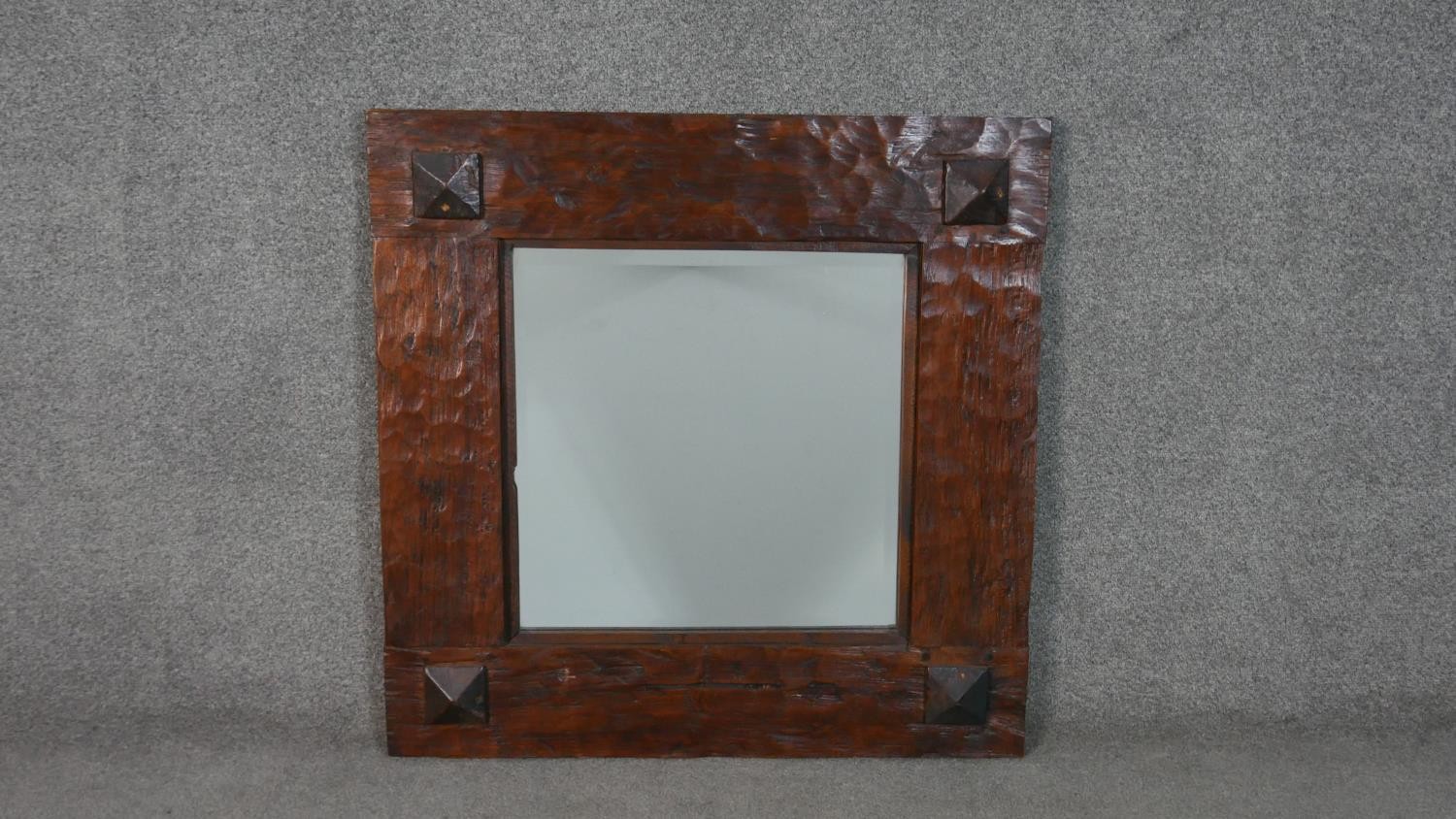 An Eastern teak square wall mirror, with a bevelled mirror plate in a rustic frame. H.80 W.80cm
