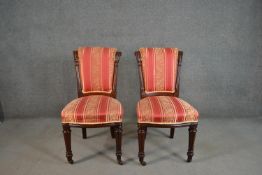 A pair of Victorian mahogany side chairs, upholstered to the back and seat in red and gold fabric,