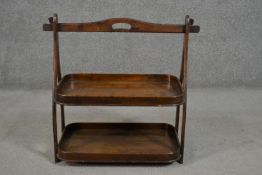 An early 20th century fruitwood cake stand, with a carrying handle over two galleried trays, and