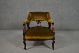 A late Victorian walnut tub chair, upholstered to the back and seat in golden velour, with a pierced