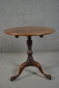 A George III mahogany tilt top tripod table, with a circular top, on a turned stem, with tripod legs