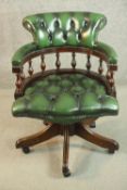 A reproduction buttoned green leather office chair, with a baluster turned back, on a five point