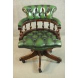 A reproduction buttoned green leather office chair, with a baluster turned back, on a five point